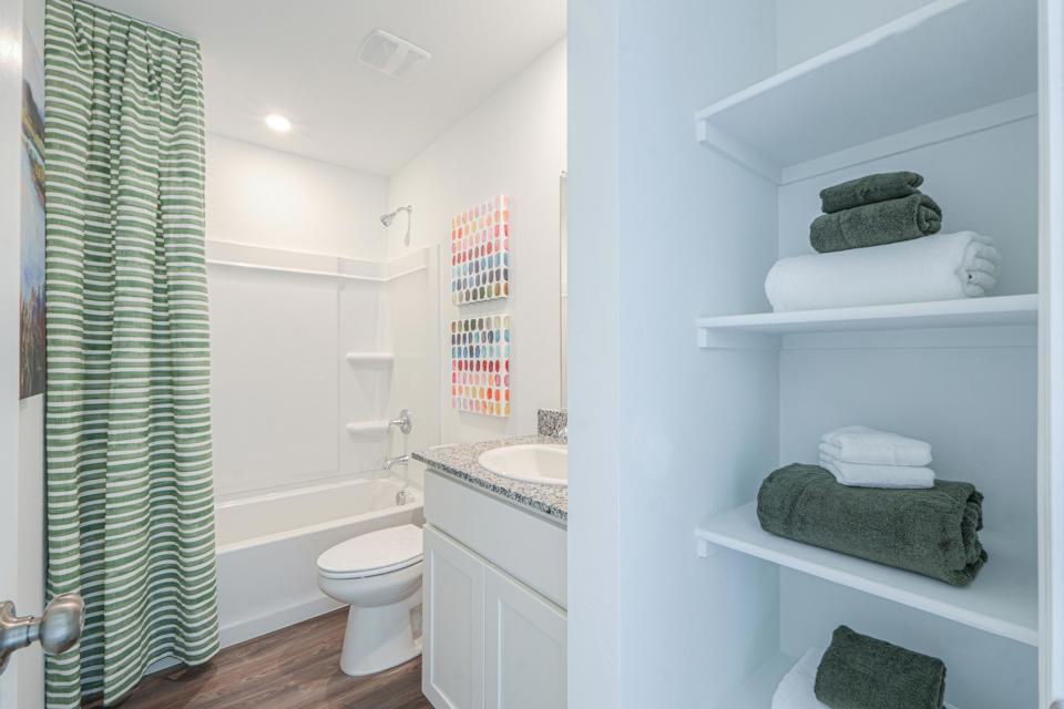 A bathroom with a sink toilet and towels.