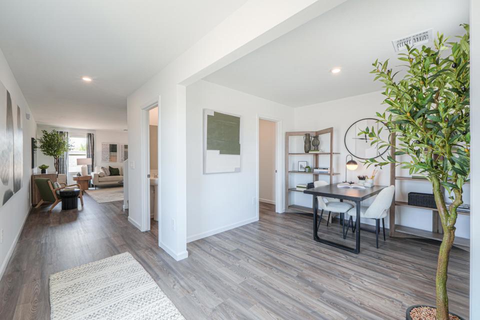 A living room with a table and chairs.
