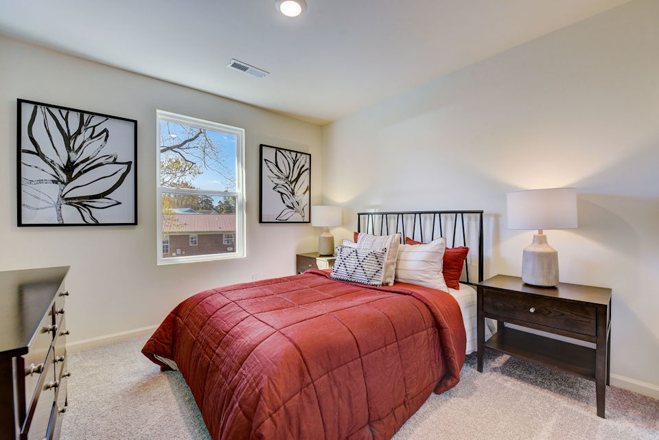 A bedroom with a bed and lamps.