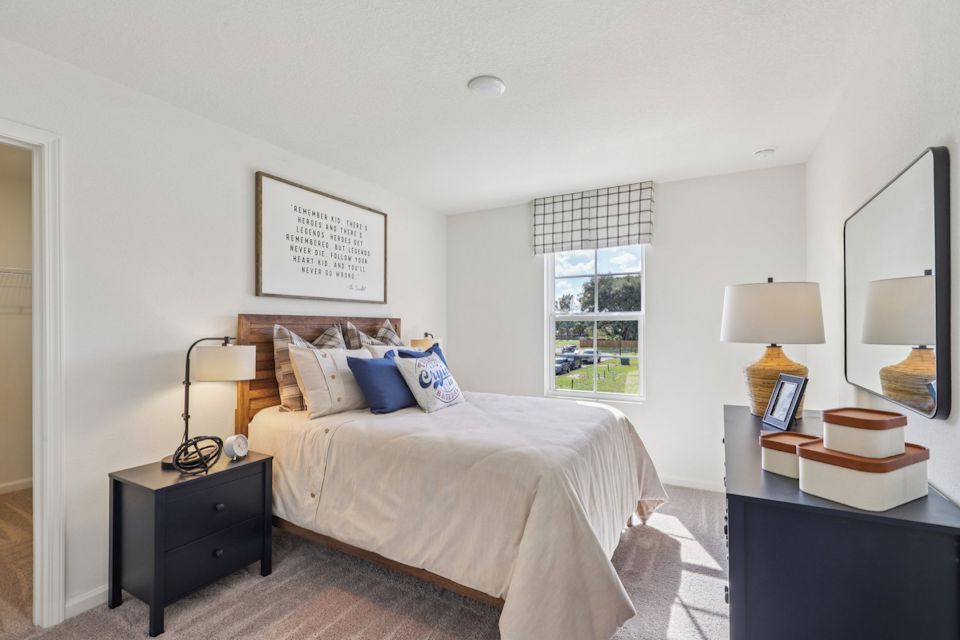 A bedroom with a bed and a mirror.