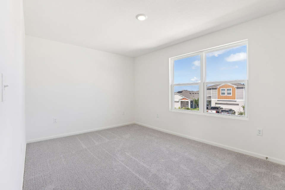 A room with a window and a carpet.