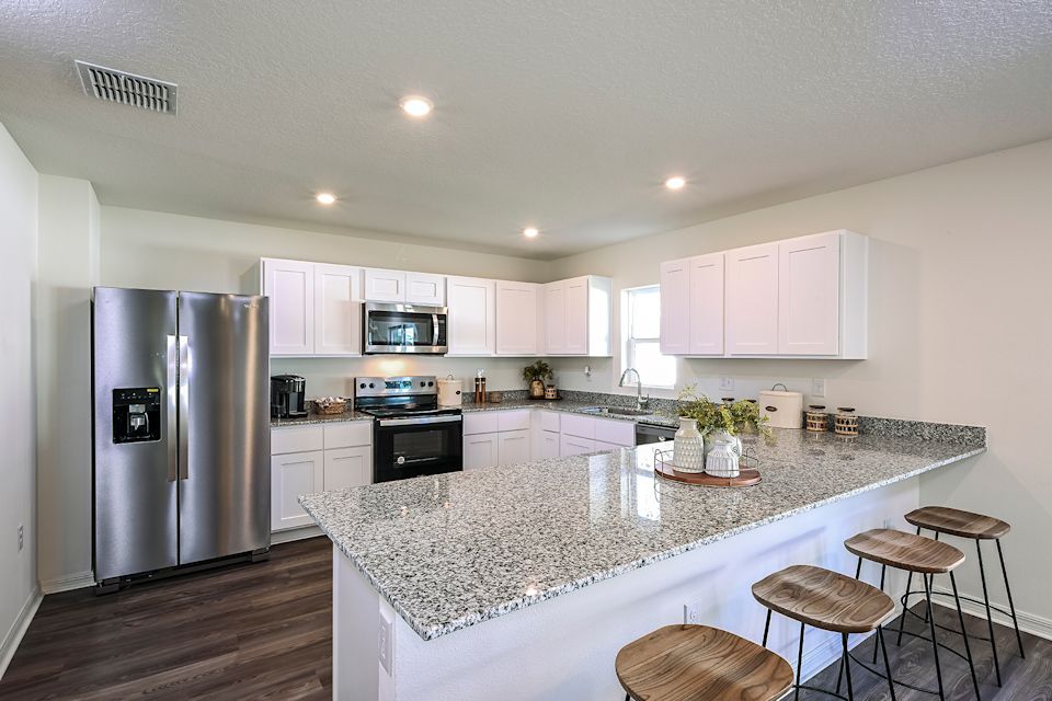 A kitchen with white cabinets.