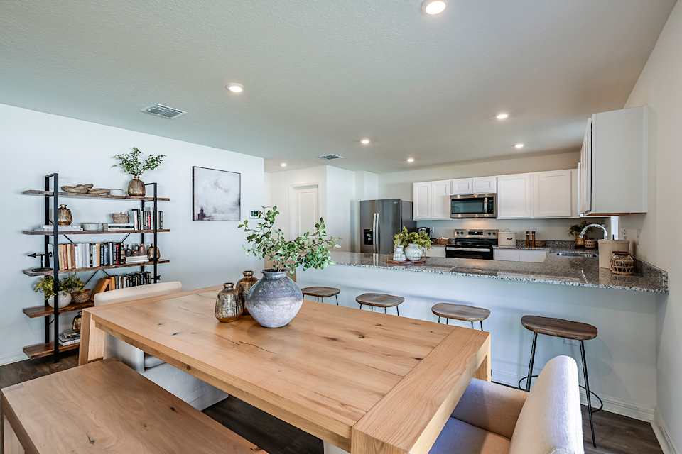 A kitchen with a table and chairs.