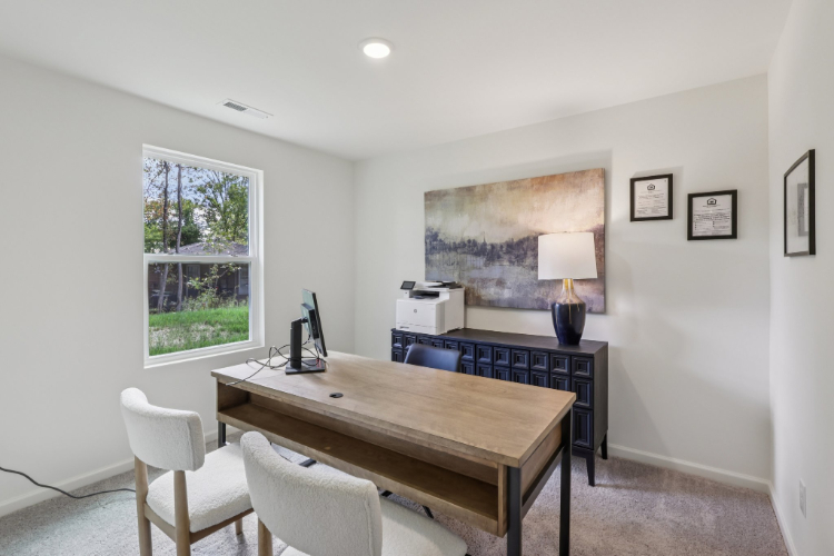 A room with a desk and chairs.