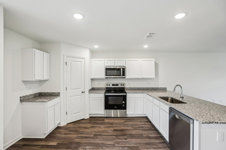 A kitchen with white cabinets.