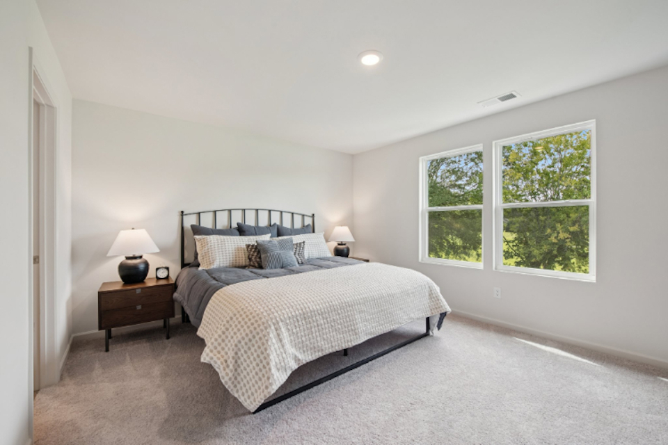 A bedroom with a bed and a window.