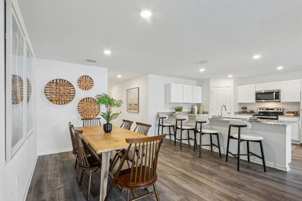 A kitchen with a dining table and chairs.
