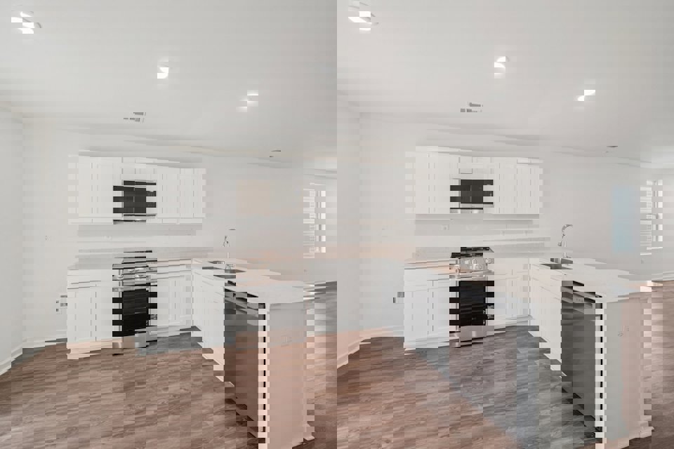 A kitchen with white cabinets.