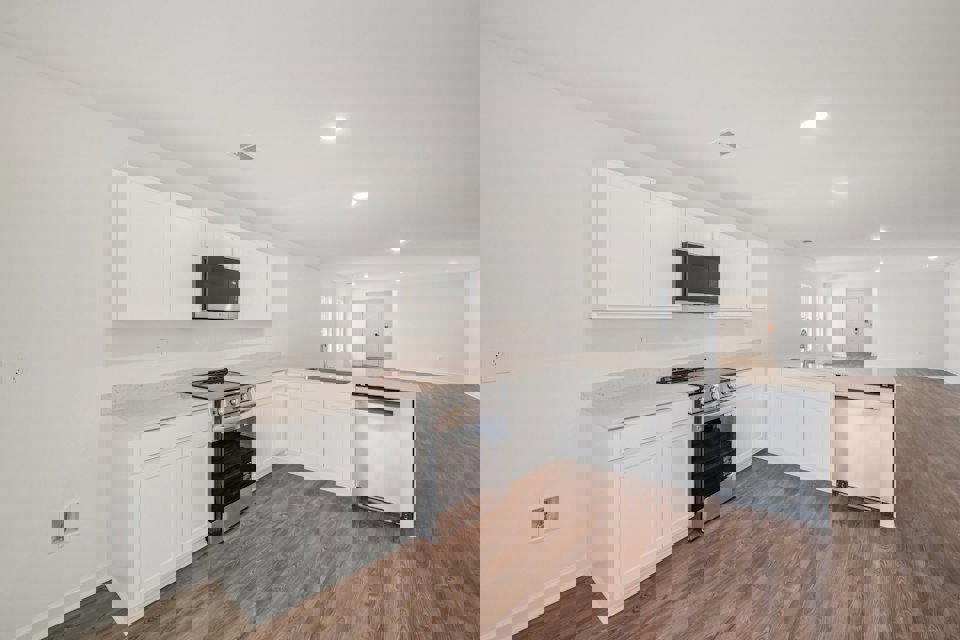 A kitchen with white cabinets.