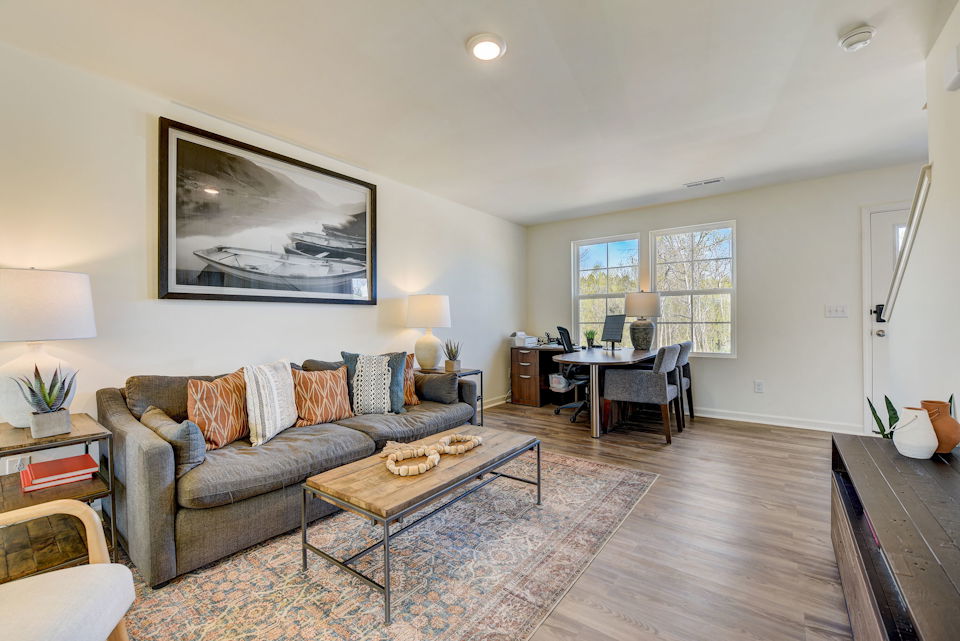 A living room with a large rug.