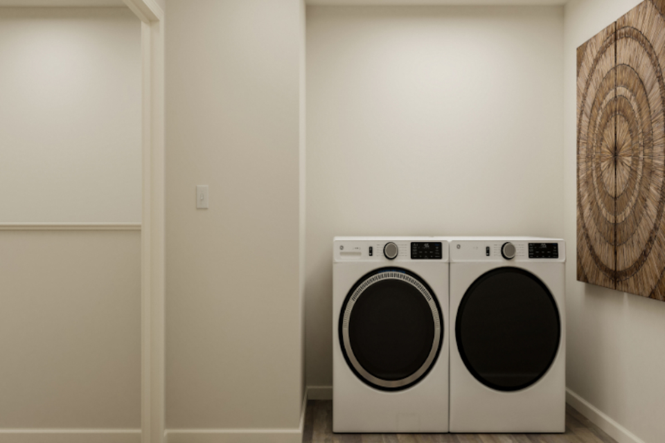 A white wall with a washing machine and a white door.