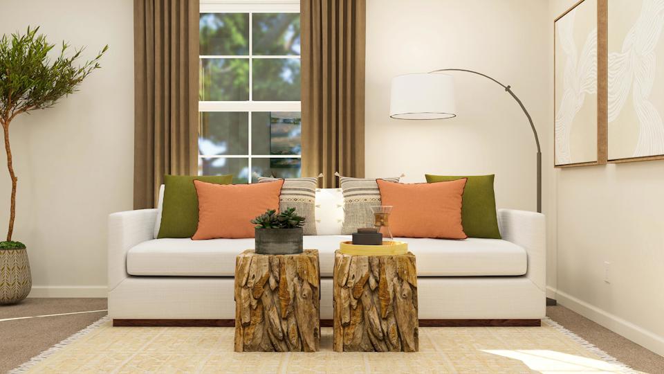 A couch with pillows and a coffee table in a room with a window.