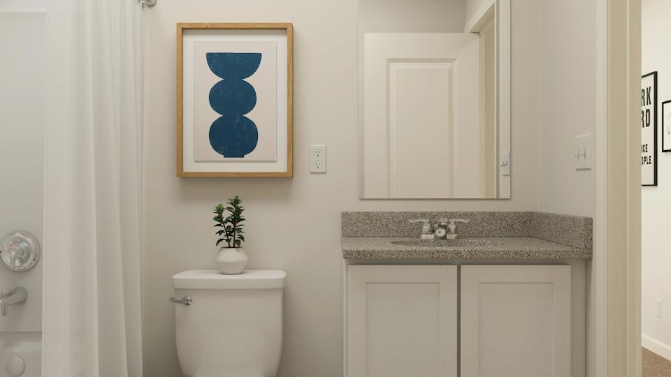 A bathroom with a painting on the wall.