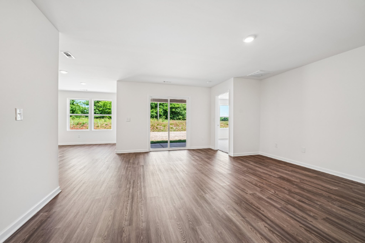 A room with a wood floor and a wood floor with a window.