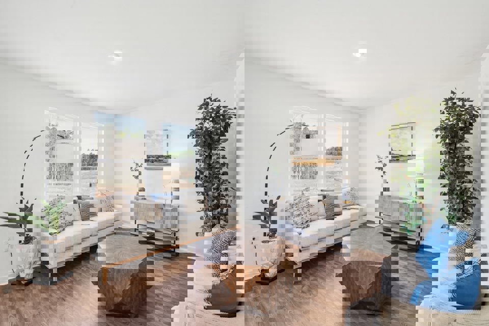 A living room with a white couch and blue pillows.