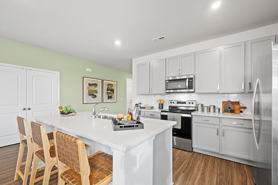 A kitchen with white cabinets.