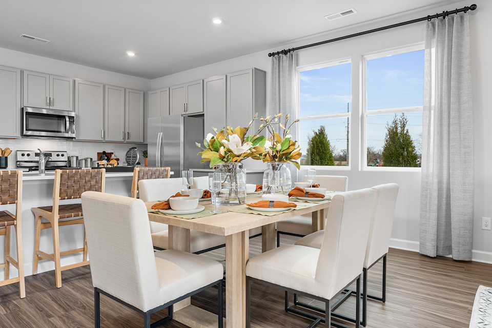 A kitchen with a dining table and chairs.