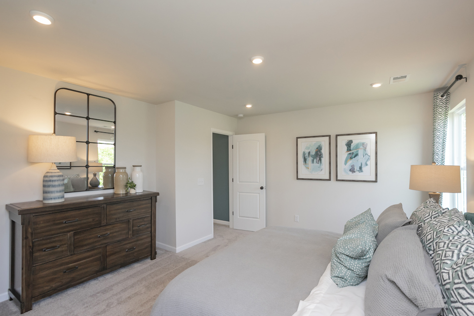 A bedroom with a bed and a dresser.