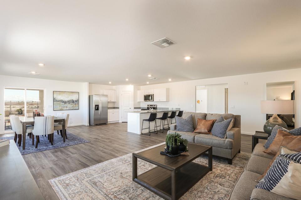 A large living room with a large dining room and a large window.