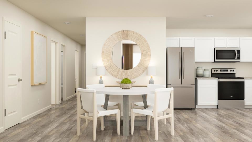 A kitchen with a dining table and white cabinets.