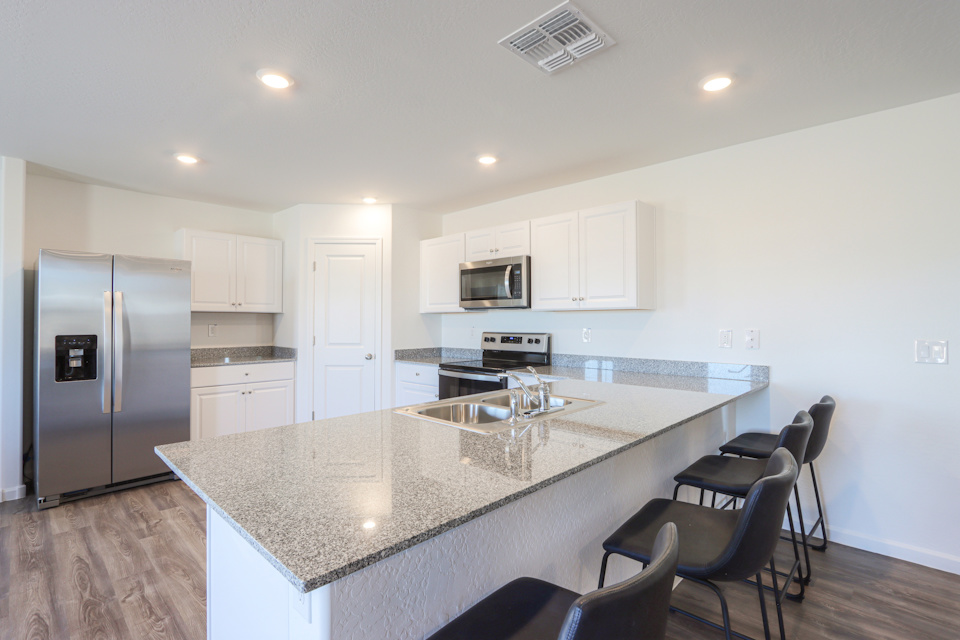 A kitchen with a marble counter.