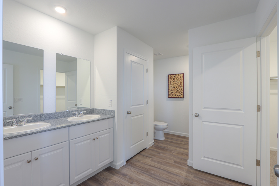 A bathroom with white cabinets.