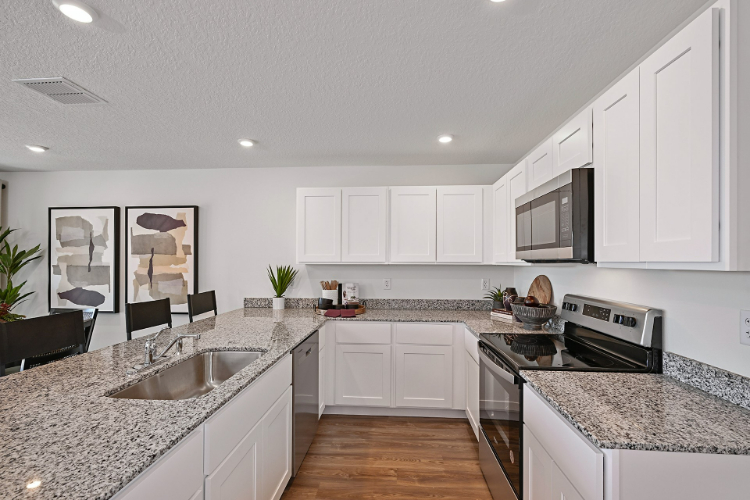 A kitchen with white cabinets.