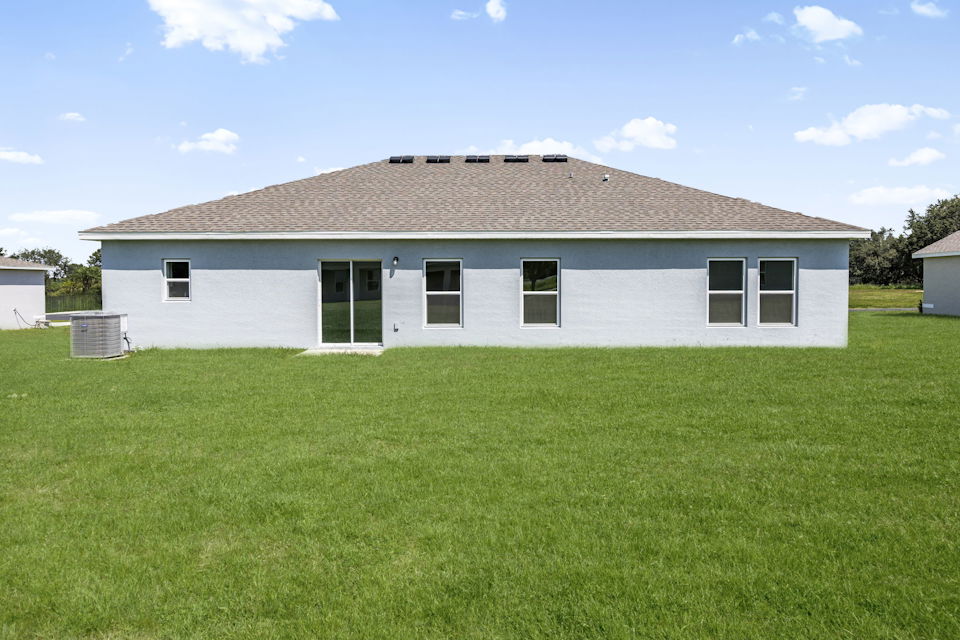 A white house with a grass yard.