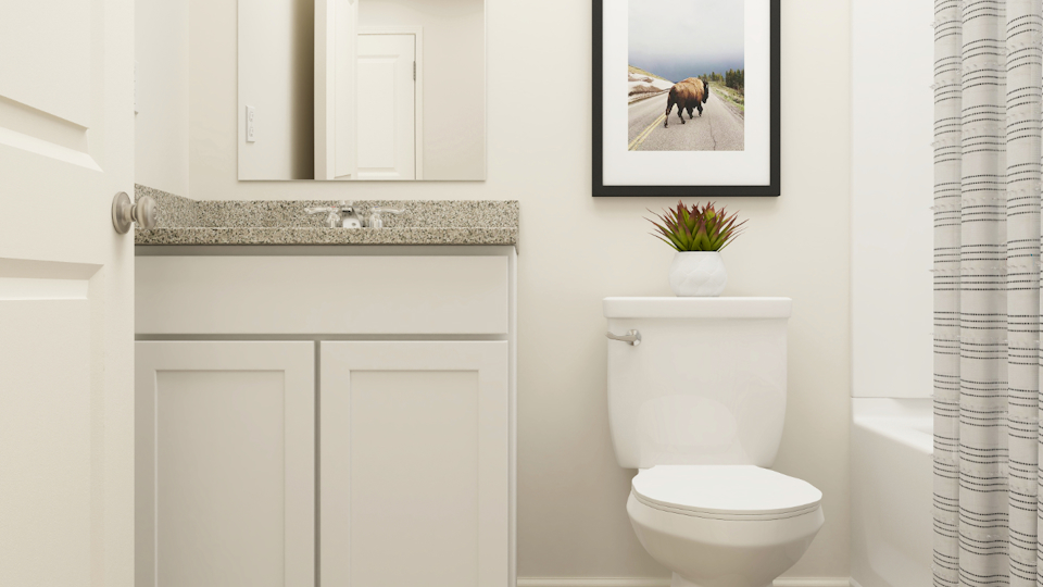 A bathroom with a toilet and a picture on the wall.