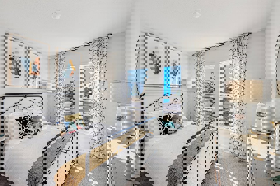 A bedroom with a bed and lamps.