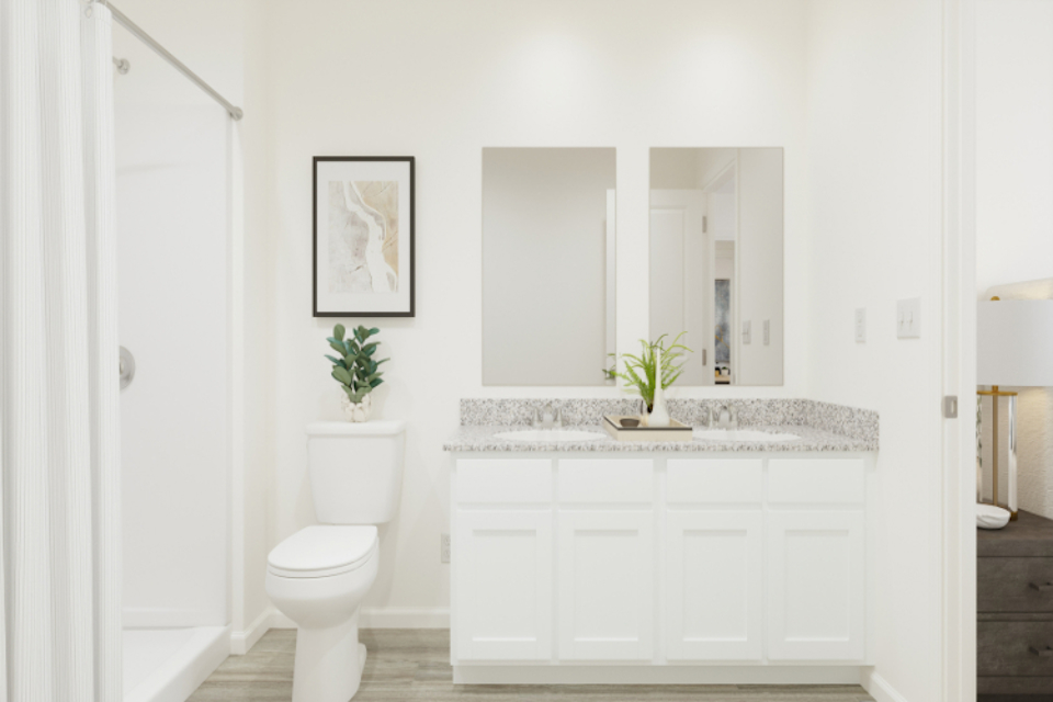 A bathroom with a sink toilet and a plant.