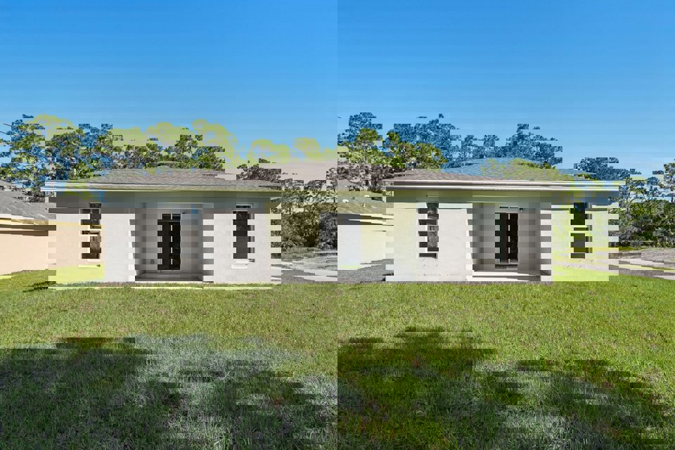 A white house with a grass yard.