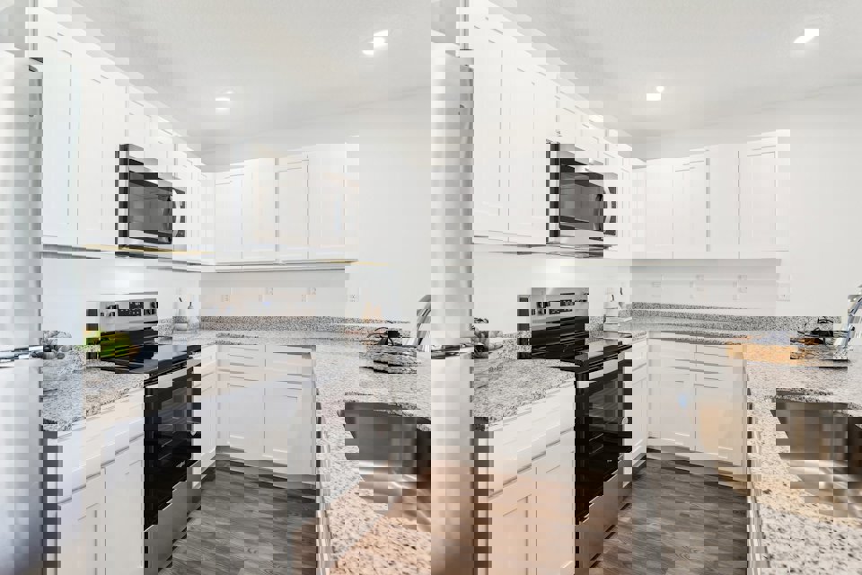 A kitchen with white cabinets.