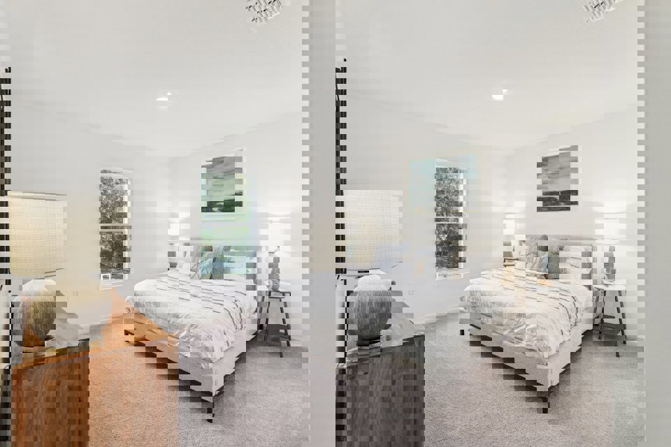 A bedroom with a bed and lamps.