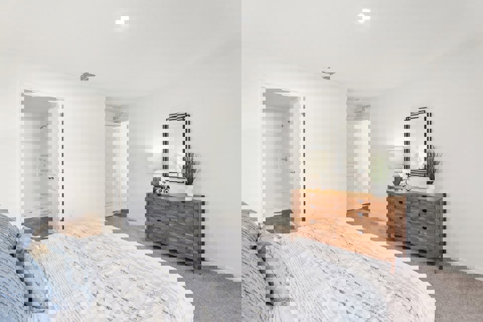 A bedroom with a bed and a dresser.