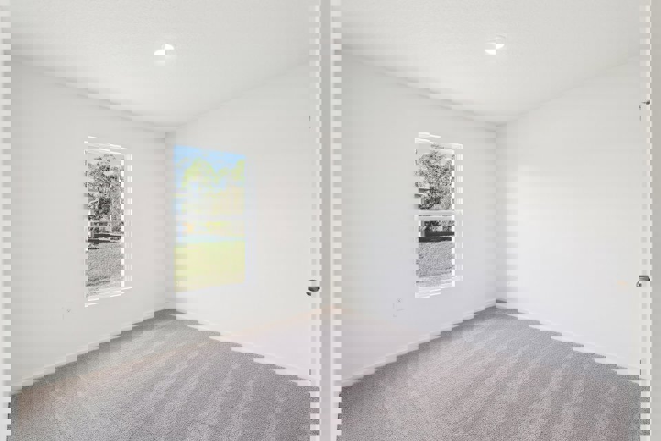 A room with a window and a carpet.