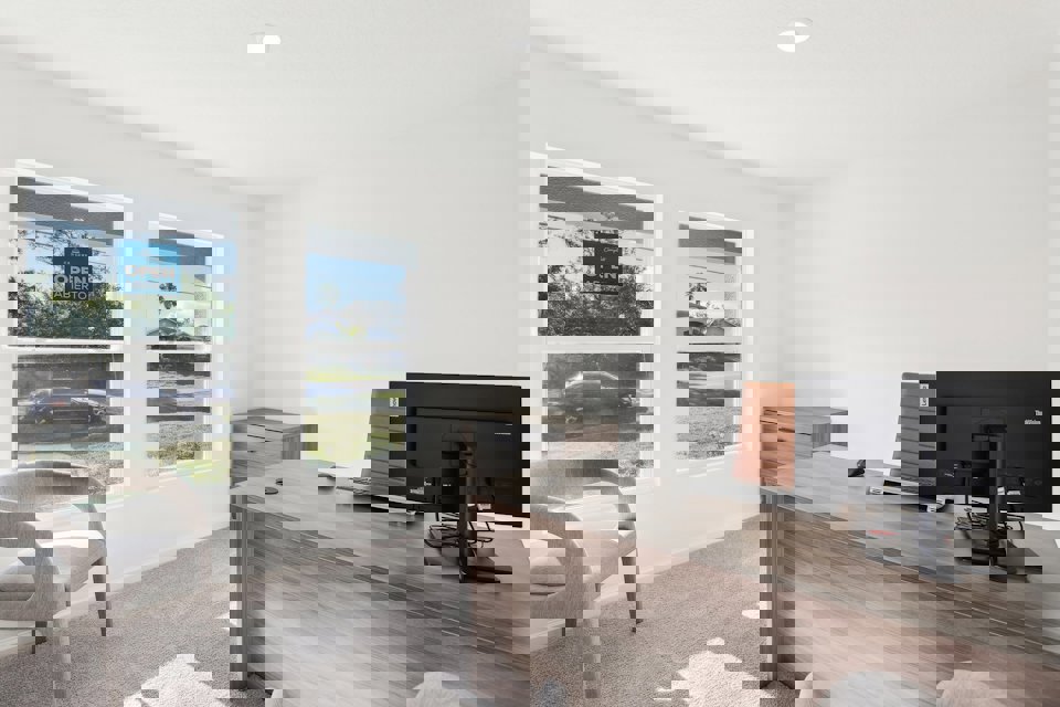 A room with a desk and a tv.