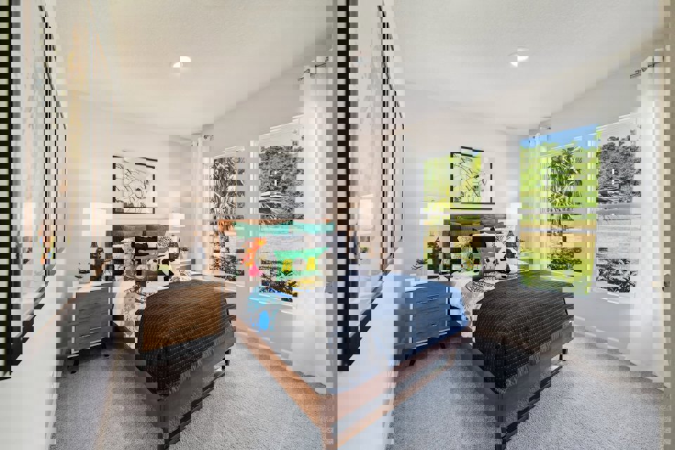 A bedroom with a bed and a window.