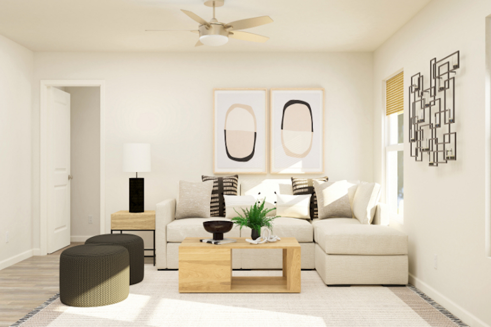 A living room with a white couch and a white ceiling fan.
