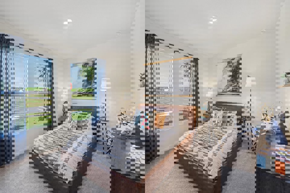 A bedroom with a large window.