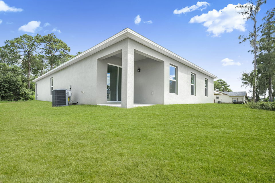A white house with a green lawn.
