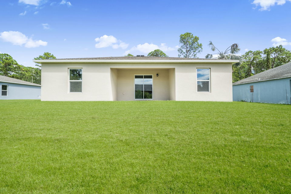 A white house with a green lawn.