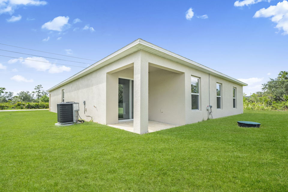 A white house with a green lawn.