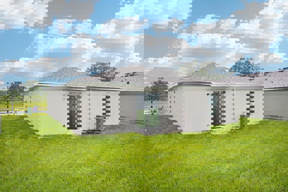 A white house with a green lawn.