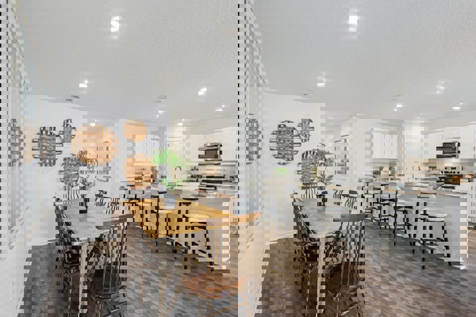 A kitchen with a dining table and chairs.