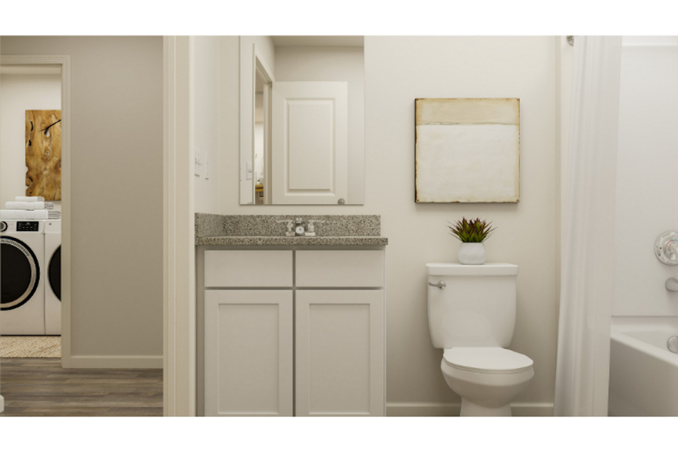 A bathroom with a sink toilet and washer.