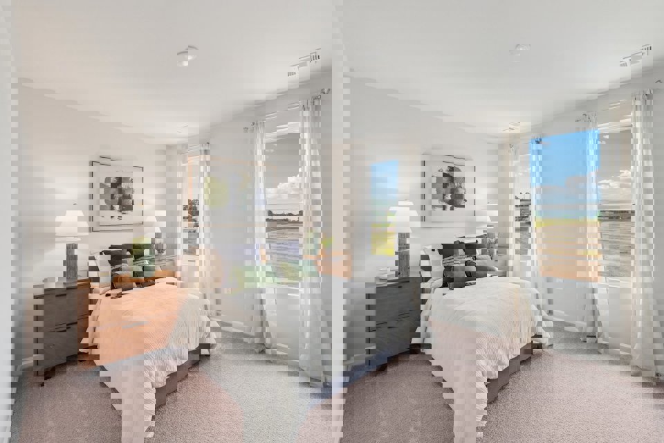 A bedroom with a large window.