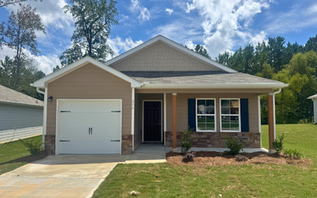 A house with a garage with Little White House in the background.