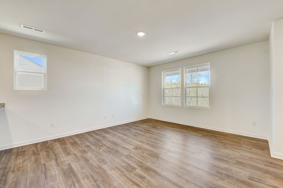 A room with a wood floor and windows.