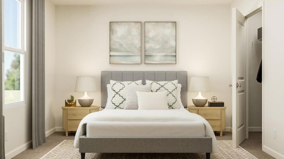 A white bed with pillows.